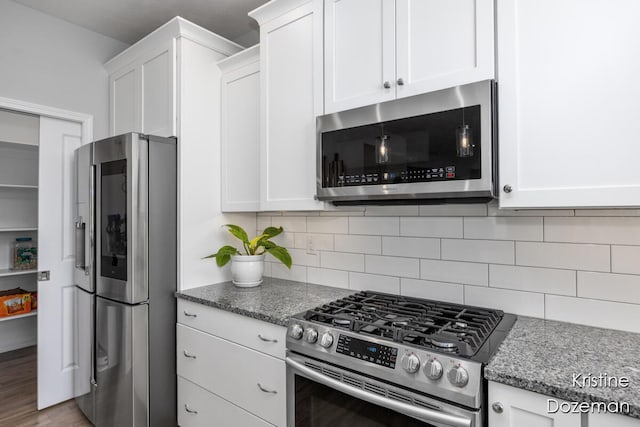12036 Harvest Home Dr, Lowell, MI 49331 - kitchen with stainless steel appliances, white cabinetry, and stone counters