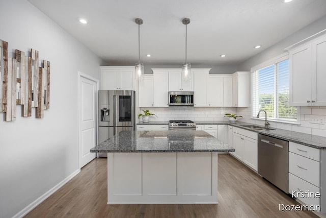 12036 Harvest Home Dr, Lowell, MI 49331 - kitchen featuring stainless steel appliances, a sink, a kitchen island, backsplash, and white cabinetry