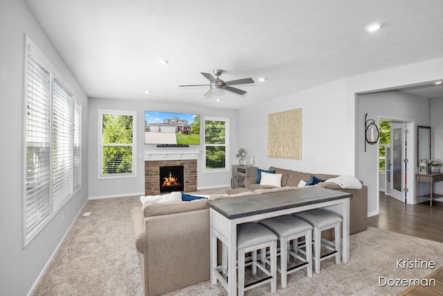 12036 Harvest Home Dr, Lowell, MI 49331 - living room with baseboards, a lit fireplace, ceiling fan, recessed lighting, and carpet floors