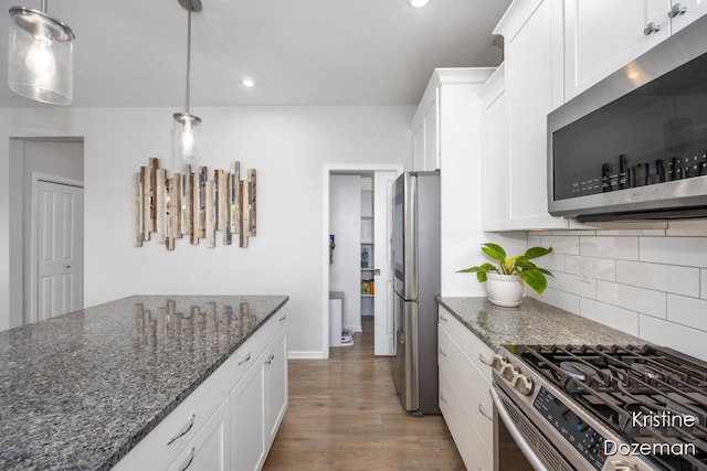 12036 Harvest Home Dr, Lowell, MI 49331 - kitchen with appliances with stainless steel finishes, white cabinets, light wood-type flooring, tasteful backsplash, and dark stone countertops