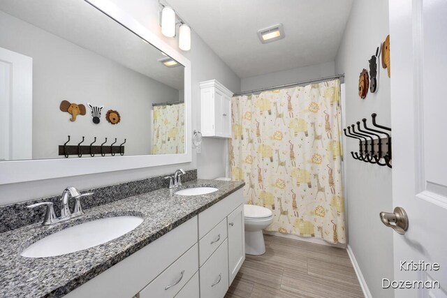 12036 Harvest Home Dr, Lowell, MI 49331 - bathroom featuring double vanity, toilet, baseboards, and curtained shower