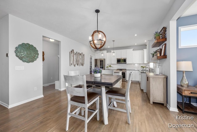 12036 Harvest Home Dr, Lowell, MI 49331 - dining space featuring light wood-type flooring, a chandelier, baseboards, and recessed lighting