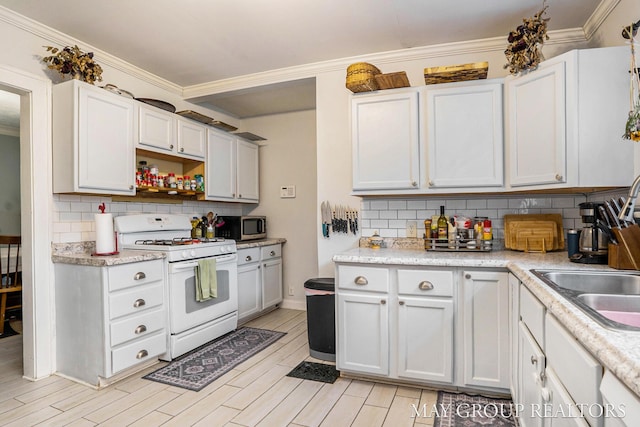 1212 Johnston St SE, Grand Rapids, MI 49507 - kitchen with white range with gas stovetop, stainless steel microwave, light countertops, tasteful backsplash, and crown molding