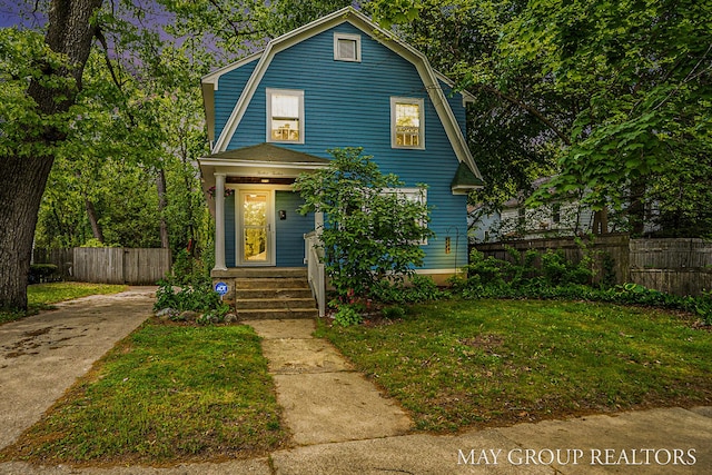 1212 Johnston St SE, Grand Rapids, MI 49507 - colonial inspired home featuring a gambrel roof, driveway, and covered porch