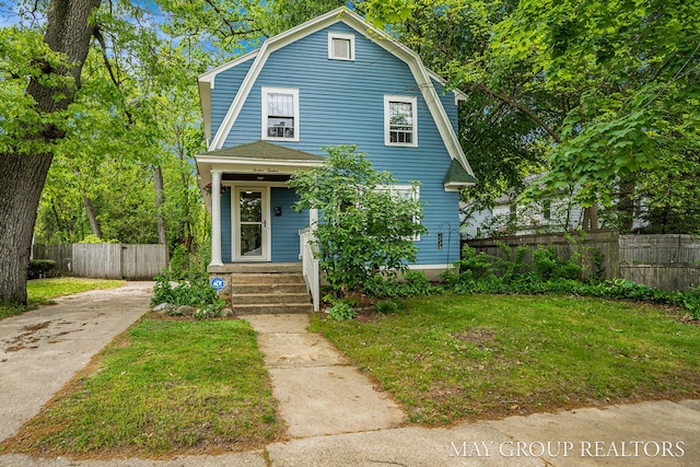 1212 Johnston St SE, Grand Rapids, MI 49507 - dutch colonial featuring a gambrel roof, a porch, and driveway