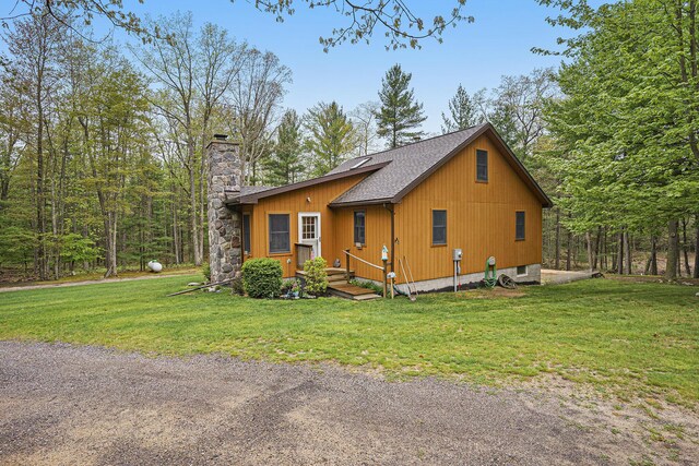 4900 N Railroad Ave, Pentwater, MI 49449 - view of front of property featuring a chimney, a front lawn, and a shingled roof