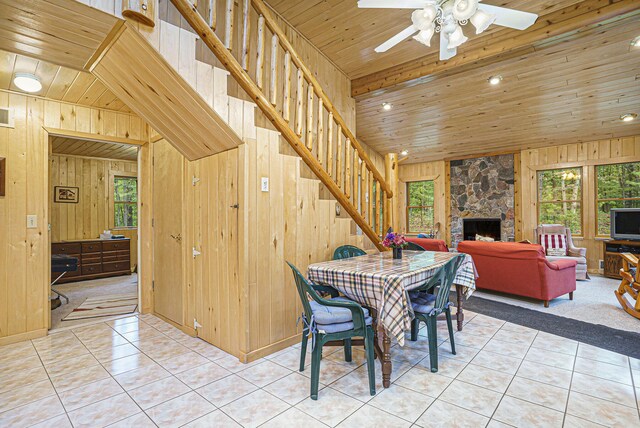 4900 N Railroad Ave, Pentwater, MI 49449 - tiled dining room with wooden ceiling, wood walls, plenty of natural light, stairway, and a ceiling fan