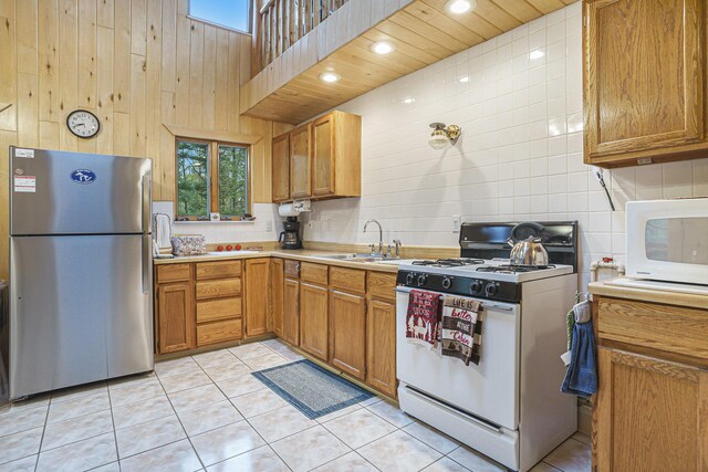 4900 N Railroad Ave, Pentwater, MI 49449 - kitchen with white appliances, a sink, light countertops, backsplash, and healthy amount of natural light