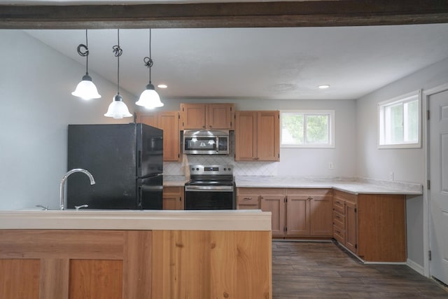 879 Carberry Rd, Niles, MI 49120 - kitchen with appliances with stainless steel finishes, dark wood-style flooring, decorative light fixtures, backsplash, and light countertops