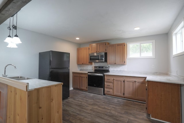 879 Carberry Rd, Niles, MI 49120 - kitchen with appliances with stainless steel finishes, dark wood-type flooring, tasteful backsplash, light countertops, and hanging light fixtures