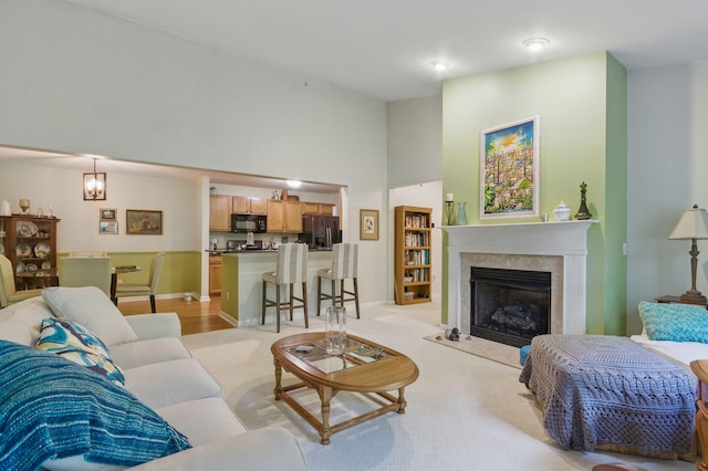 9285 Nature View Ln, Ypsilanti, MI 48197 - living room featuring a premium fireplace, a high ceiling, baseboards, and light carpet
