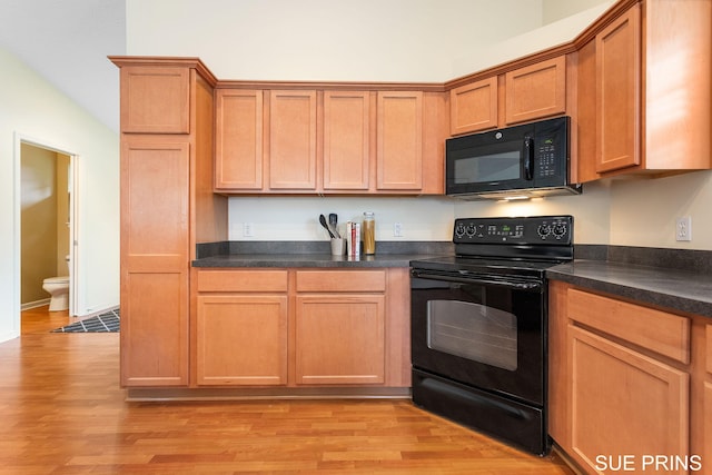 3107 Rain Tree Ct Unit 36, Hudsonville, MI 49426 - kitchen with black appliances, light wood-type flooring, dark countertops, and brown cabinetry