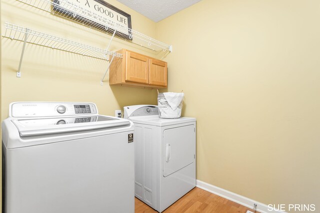 3107 Rain Tree Ct Unit 36, Hudsonville, MI 49426 - washroom with separate washer and dryer, cabinet space, light wood-style flooring, and baseboards