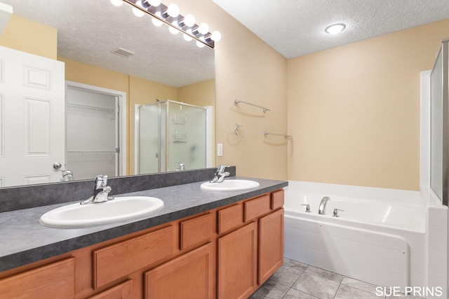 3107 Rain Tree Ct Unit 36, Hudsonville, MI 49426 - bathroom featuring a textured ceiling, a shower stall, double vanity, a garden tub, and tile patterned flooring