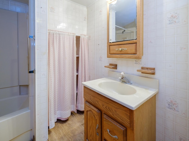 12391 Sunset Dr, Plainwell, MI 49080 - bathroom featuring tile walls, vanity, wood finished floors, and shower / tub combo with curtain