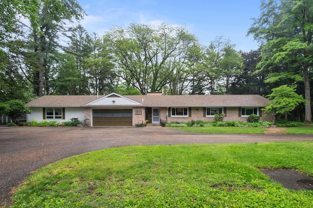 1119 Wesaw Rd, Niles, MI 49120 - single story home with a garage, asphalt driveway, a front yard, and a chimney
