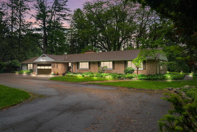 1119 Wesaw Rd, Niles, MI 49120 - ranch-style home featuring an attached garage, asphalt driveway, brick siding, a front lawn, and a chimney