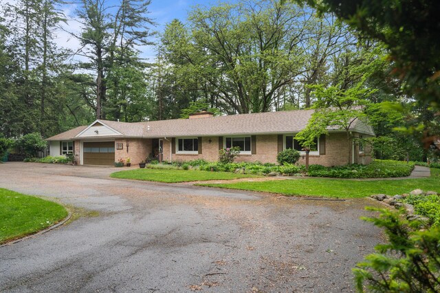 1119 Wesaw Rd, Niles, MI 49120 - ranch-style home with an attached garage, asphalt driveway, brick siding, and a front yard