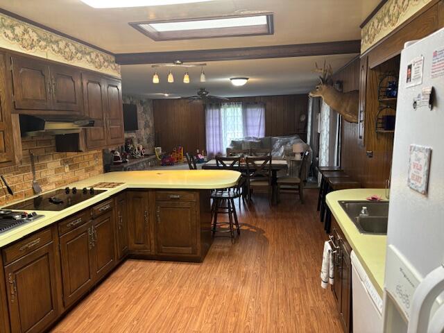 18593 30th Ave, Barryton, MI 49305 - kitchen with white appliances, a peninsula, light countertops, light wood-style floors, and a sink