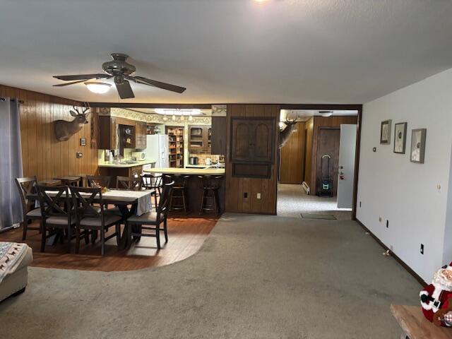 18593 30th Ave, Barryton, MI 49305 - carpeted dining space featuring wooden walls and a ceiling fan