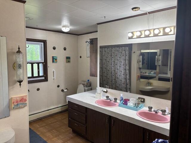 18593 30th Ave, Barryton, MI 49305 - bathroom with a baseboard radiator, double vanity, toilet, and a shower with curtain
