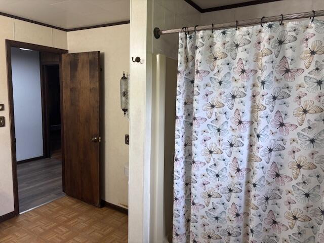 18593 30th Ave, Barryton, MI 49305 - bathroom with baseboards, a shower with shower curtain, crown molding, and parquet flooring