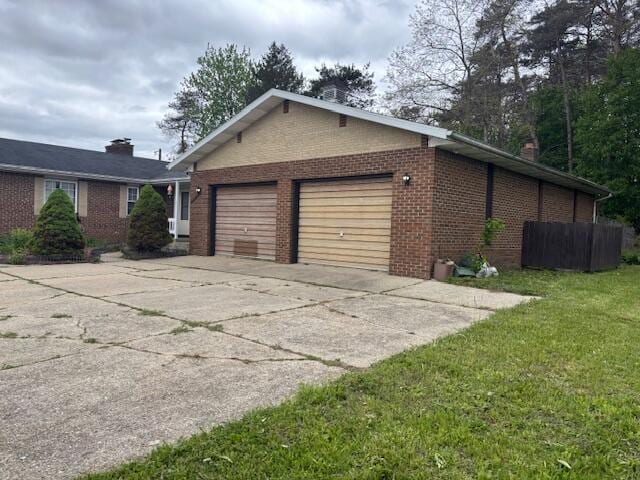 18593 30th Ave, Barryton, MI 49305 - view of side of home with brick siding, driveway, an attached garage, a chimney, and a yard