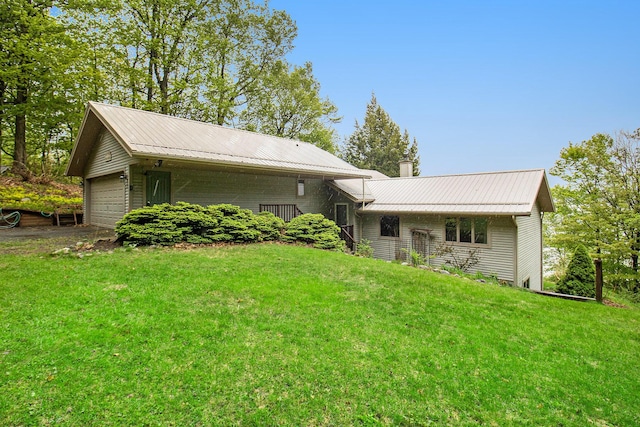 6818 W Vesper Dr, Ludington, MI 49431 - back of property featuring metal roof, a yard, and a chimney