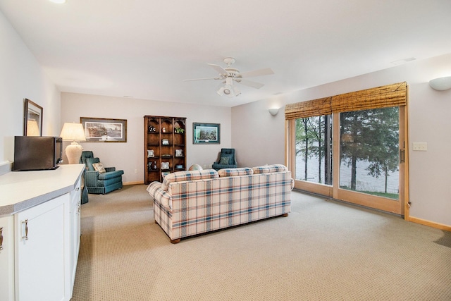 6818 W Vesper Dr, Ludington, MI 49431 - living room with light colored carpet, a ceiling fan, and baseboards