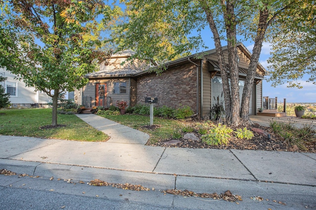 226 Sunset Ave NW, Grand Rapids, MI 49504 - view of front of house featuring a front yard, brick siding, and an attached garage
