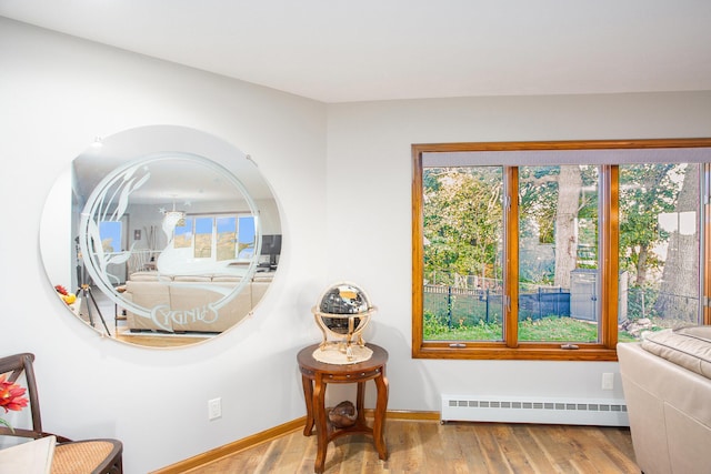226 Sunset Ave NW, Grand Rapids, MI 49504 - living area featuring a baseboard heating unit, wood finished floors, and baseboards