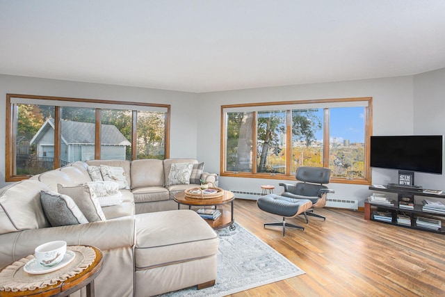 226 Sunset Ave NW, Grand Rapids, MI 49504 - living room featuring wood finished floors, a baseboard heating unit, baseboards, and a baseboard radiator