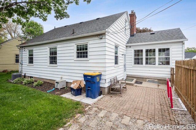 2052 Gorham Dr SE, East Grand Rapids, MI 49506 - back of property with a patio area, a shingled roof, a chimney, and central AC