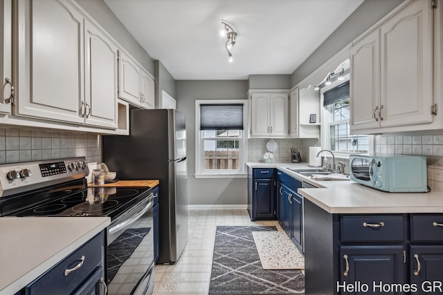 2052 Gorham Dr SE, East Grand Rapids, MI 49506 - kitchen featuring electric range, blue cabinetry, a sink, white cabinets, and light countertops