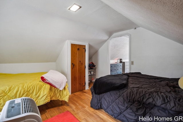 2052 Gorham Dr SE, East Grand Rapids, MI 49506 - bedroom featuring wood finished floors, vaulted ceiling, and a textured ceiling