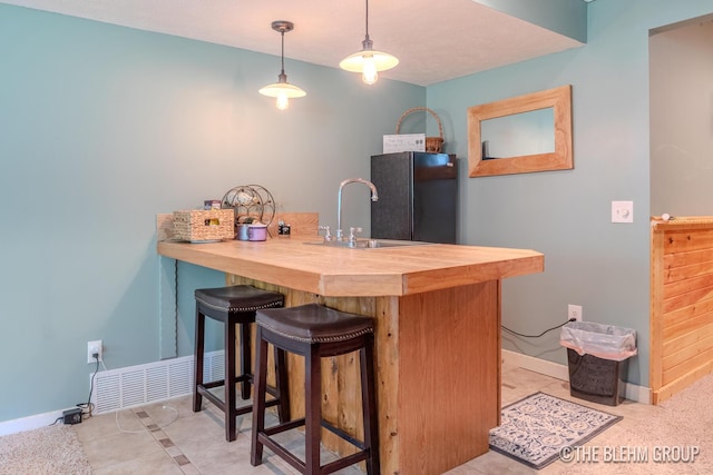 1705 Fritz St, Marne, MI 49435 - bar area with freestanding refrigerator, hanging light fixtures, and light tile patterned flooring