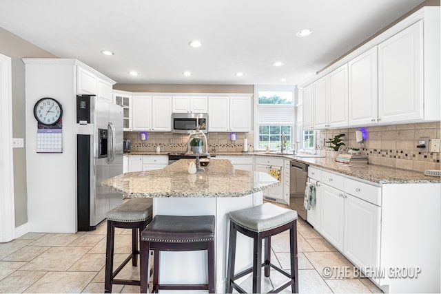 1705 Fritz St, Marne, MI 49435 - kitchen with appliances with stainless steel finishes, a kitchen breakfast bar, backsplash, white cabinets, and recessed lighting