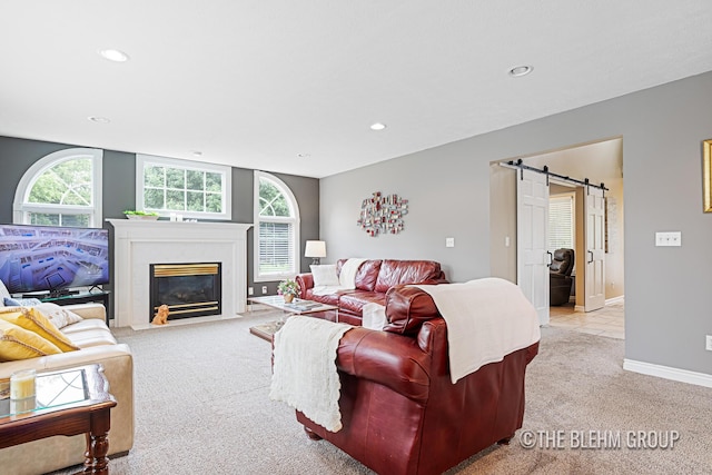 1705 Fritz St, Marne, MI 49435 - living area featuring a barn door, light colored carpet, healthy amount of natural light, recessed lighting, and a fireplace with flush hearth