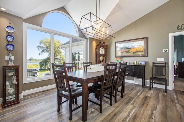 14776 Park Ct, Grand Haven, MI 49417 - dining room featuring wood finished floors, baseboards, a chandelier, and high vaulted ceiling