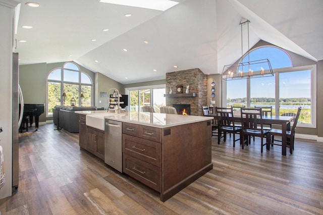 14776 Park Ct, Grand Haven, MI 49417 - kitchen with vaulted ceiling, a sink, open floor plan, stainless steel appliances, and a fireplace