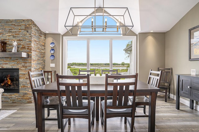 14776 Park Ct, Grand Haven, MI 49417 - dining room with healthy amount of natural light, a chandelier, wood finished floors, and a fireplace