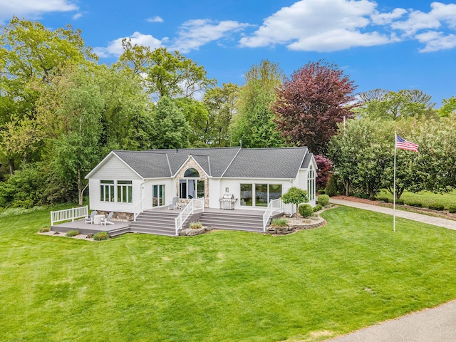 14776 Park Ct, Grand Haven, MI 49417 - view of front facade featuring a wooden deck, a front lawn, concrete driveway, and view of wooded area