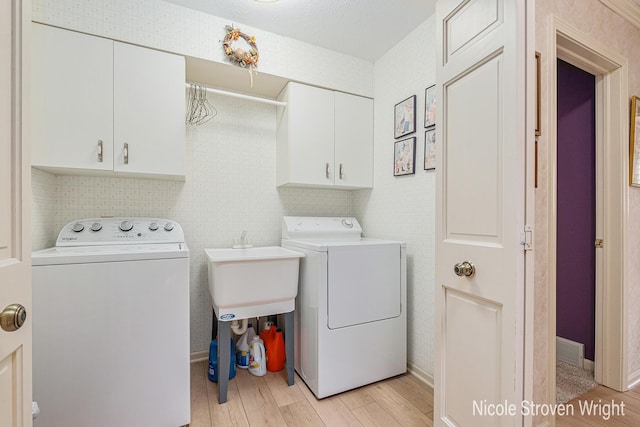 4124 Cummings Ct NW, Grand Rapids, MI 49534 - laundry area featuring washing machine and clothes dryer, light wood-type flooring, cabinet space, and baseboards