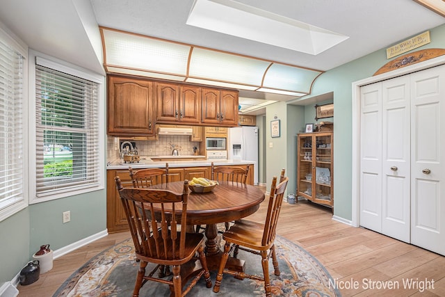 4124 Cummings Ct NW, Grand Rapids, MI 49534 - dining area featuring light wood-type flooring, baseboards, and a skylight