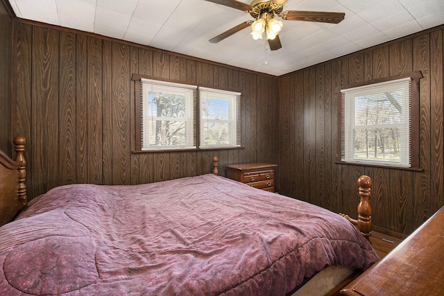 7034 W Dewey Rd, Ludington, MI 49431 - bedroom with wood walls and ceiling fan