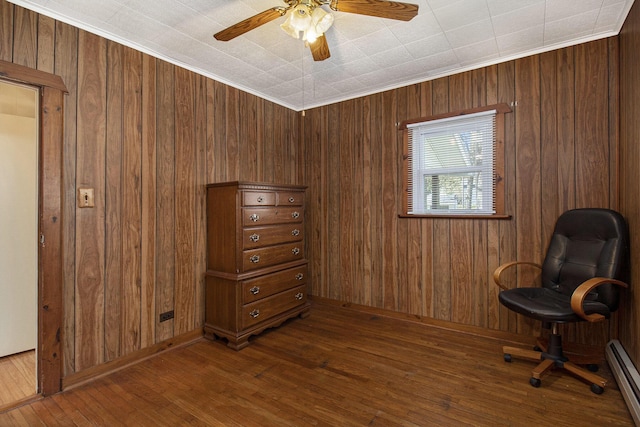 7034 W Dewey Rd, Ludington, MI 49431 - sitting room with a baseboard heating unit, hardwood / wood-style flooring, a ceiling fan, and wooden walls