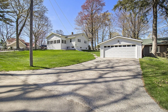 7034 W Dewey Rd, Ludington, MI 49431 - view of front of property with an outbuilding, a front lawn, driveway, and a garage
