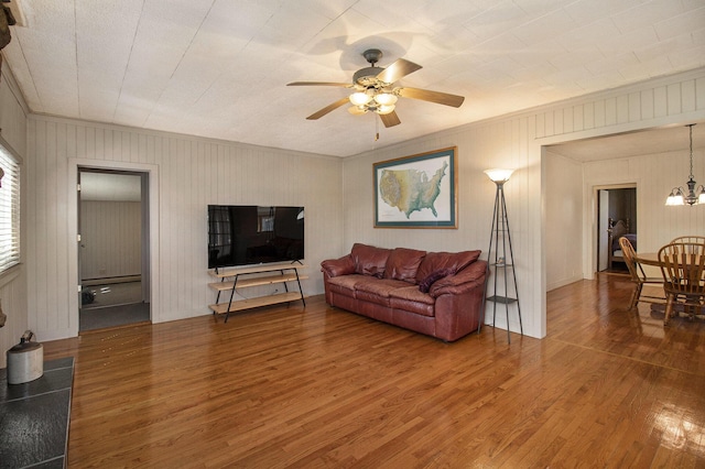 7034 W Dewey Rd, Ludington, MI 49431 - living area with wood finished floors, ornamental molding, a ceiling fan, a chandelier, and wood walls