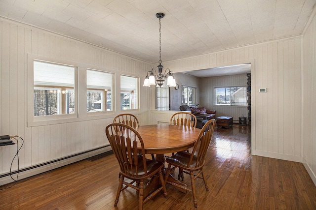 7034 W Dewey Rd, Ludington, MI 49431 - dining space featuring a baseboard heating unit, hardwood / wood-style floors, a chandelier, crown molding, and wood walls