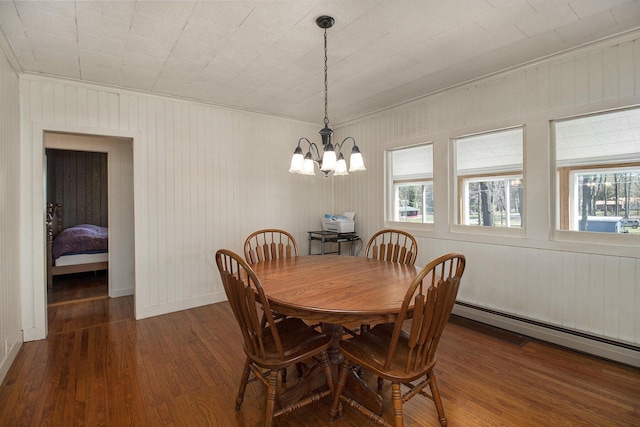 7034 W Dewey Rd, Ludington, MI 49431 - dining space featuring hardwood / wood-style flooring, crown molding, a chandelier, baseboard heating, and baseboards